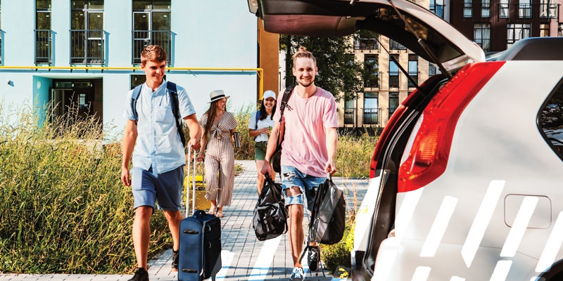 Young adults loading a car with luggage