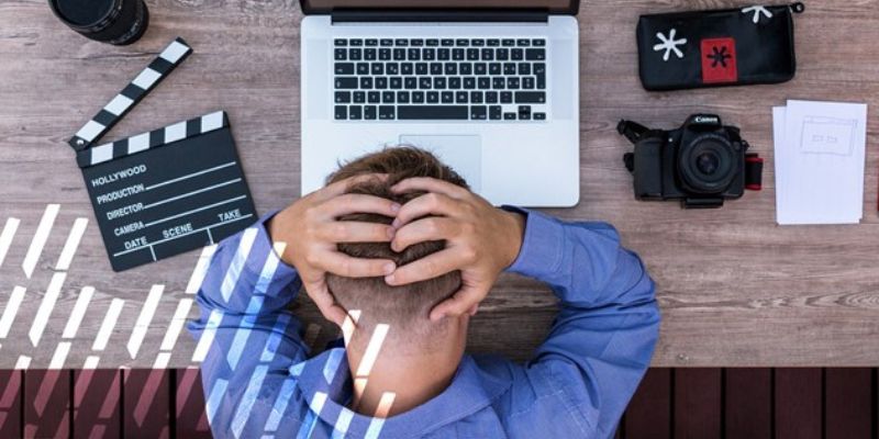 Person with head down in front of laptop